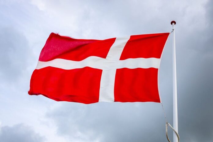 Danebrog flagrer i vinden på en overskyet dag