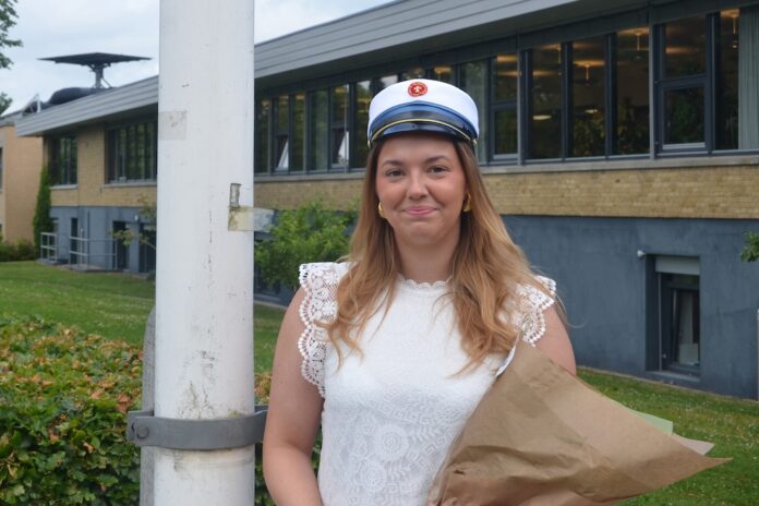 Frederikke Hjorth Binderup fejres som årets første student på Mariagerfjord Gymnasium med blomster og studenterhue.