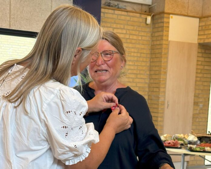 Lærer modtager H.M. Kongens belønningsmedalje efter mange års undervisning og internationalt arbejde.