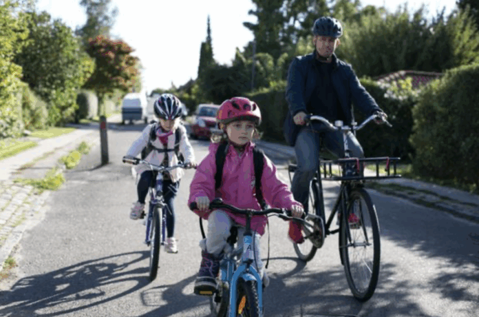 Skolebørn på cykel og til fods på vej til skole som led i kampagne om trafiksikkerhed og mindre biltrafik ved skoler.
