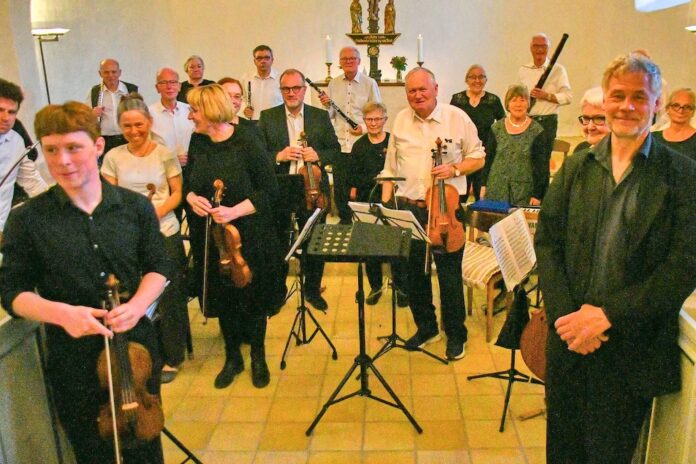 Hobro Kammerorkester spiller koncert i Glenstrup Kirke med dirigent og musikere samlet på scenen
