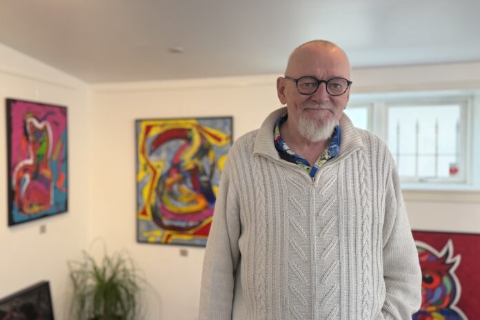 Jesper Norup i Amadusa-atelieret på Østergade i Hobro omgivet af sine malerier