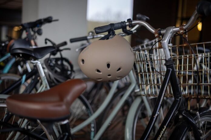 Teenagere og børn med cykelhjelm på cykeltur sammen med deres forældre.