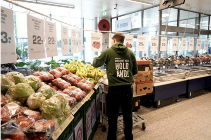 En ung medarbejder er i gang med sit første fritidsjob i en dagligvarebutik, hvor nye regler giver et større økonomisk udbytte.
